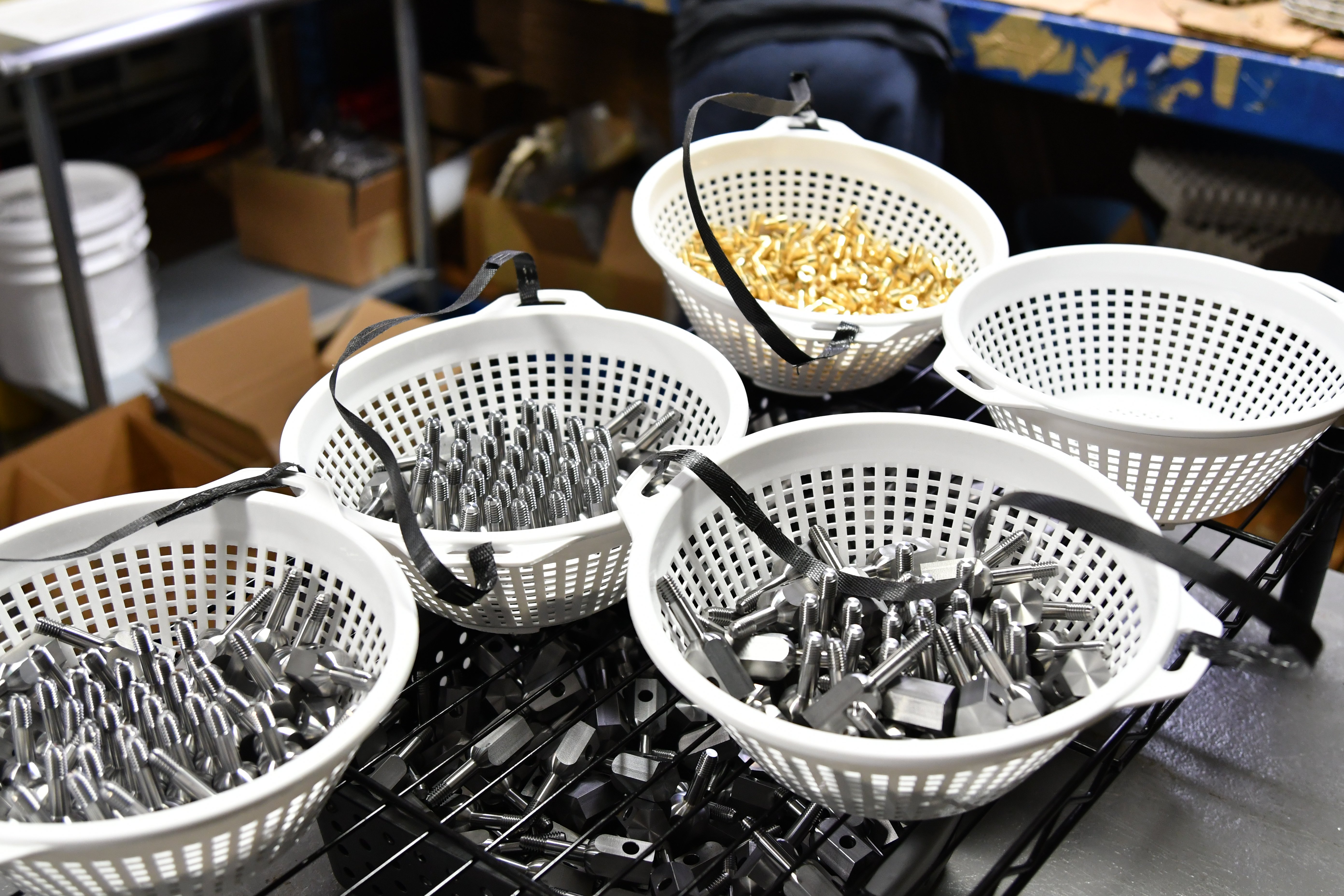 Sample parts made by Precision Turning Specialties shown in baskets before washing